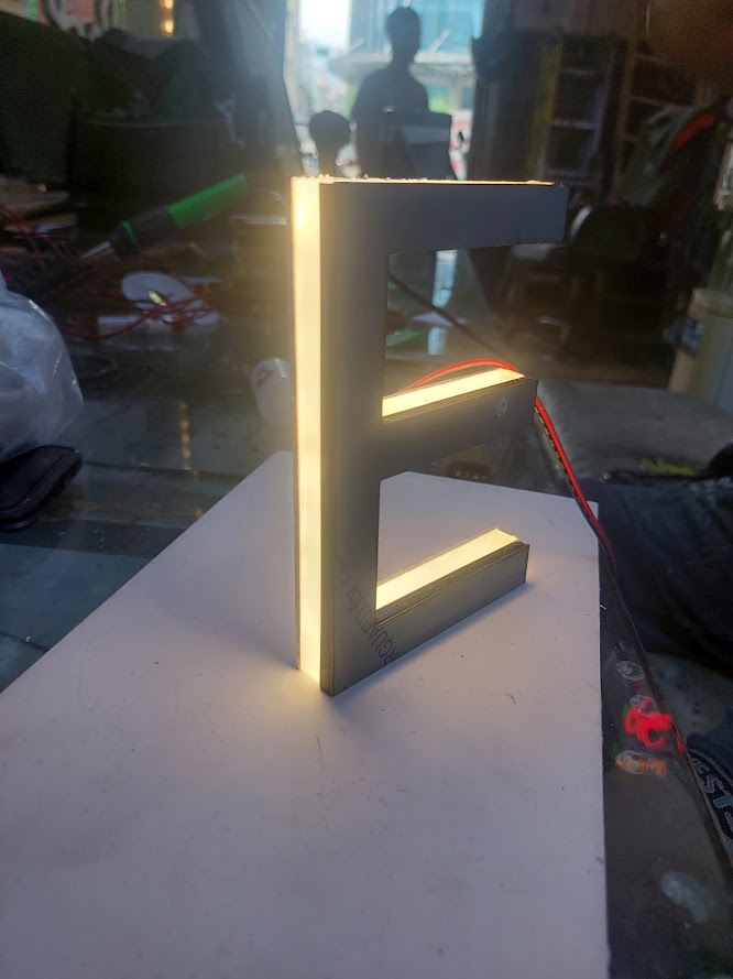 <p>📌 Chữ nổi inox đèn sáng chân là gì?</p>

<p>Chữ nổi inox đèn sáng chân là loại chữ quảng cáo được gia công từ inox – chất liệu kim loại cao cấp, sáng bóng – kết hợp với hệ thống đèn LED gắn bên dưới, tạo hiệu ứng ánh sáng phát ra từ phần chân chữ, giúp tên thương hiệu, logo nổi bật trên nền bảng hiệu vào ban đêm.</p>

<p>Đây là dòng sản phẩm cao cấp, thường được sử dụng trong bảng hiệu công ty, nhà hàng, showroom, khách sạn, ngân hàng... mang đến sự đẳng cấp, chuyên nghiệp và độ nhận diện thương hiệu vượt trội.</p>

<p>✅ Ưu điểm vượt trội của chữ nổi inox đèn sáng chân</p>

<p>💎 Chất liệu inox cao cấp: Sáng bóng, không rỉ sét, không bong tróc theo thời gian</p>

<p>💡 Ánh sáng chân mềm mại, hiện đại: Đèn LED hắt sáng từ dưới lên, tạo hiệu ứng nền ấn tượng</p>

<p>🎨 Tùy chọn màu sắc đèn LED: Trắng, vàng, xanh dương, đỏ... tùy theo thiết kế thương hiệu</p>

<p>💪 Chịu được thời tiết khắc nghiệt: Lý tưởng cho cả môi trường trong nhà & ngoài trời</p>

<p>🔧 Gia công sắc nét – tỉ mỉ từng chi tiết: Đảm bảo sự sang trọng và tinh tế</p>

<p>🔋 Tiết kiệm điện – độ bền cao: LED tuổi thọ lên đến 50.000 giờ, hoạt động ổn định</p>

<p>📍 Ứng dụng của chữ inox đèn sáng chân</p>

<p>🏢 Logo công ty tại văn phòng, sảnh tòa nhà</p>

<p>🏬 Biển hiệu showroom, trung tâm thương mại, phòng trưng bày</p>

<p>🍽️ Nhà hàng, khách sạn, quán café cao cấp</p>

<p>🏦 Ngân hàng, cửa hàng vàng bạc, spa thẩm mỹ</p>

<p>🎯 Bảng chỉ dẫn – bảng tên phòng ban – logo nội thất</p>

<p>🔎 Các loại chữ nổi inox đèn sáng chân phổ biến</p>

<p>Chữ inox vàng sáng chân – Đẳng cấp & sang trọng</p>

<p>Chữ inox trắng sáng chân LED trắng – Thanh lịch, chuyên nghiệp</p>

<p>Chữ inox xước + đèn LED vàng ấm – Mềm mại và hiện đại</p>

<p>Chữ inox đen gương + đèn LED xanh/đỏ – Cá tính, nổi bật</p>

<p>Chữ inox kết hợp mica mặt + sáng chân LED – Tạo chiều sâu ánh sáng độc đáo</p>